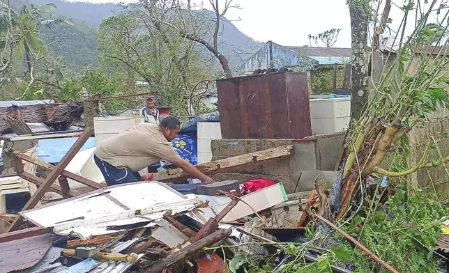 In this photo provided by the MDRRMO Viga Catanduanes, a resident recovers belongings from their damaged homes caused by Typhoon Man-yi in Viga, Catanduanes province, northeastern Philippines Sunday, Nov. 17, 2024. (MDRRMO Viga Catanduanes via AP)