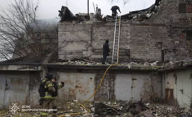 In this photo provided by the Ukrainian Emergency Services on Nov. 21, 2024, rescue workers put out a fire of a building which was heavily damaged by a Russian strike on Dnipro, Ukraine. (Ukrainian Emergency Service via AP)