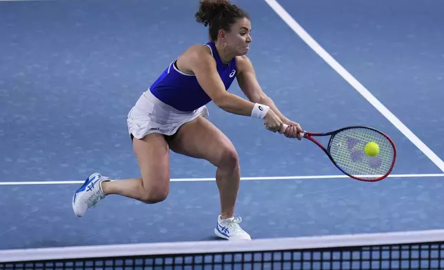 Italy's Jasmine Paolini returns the ball against Poland's Iga Swiatek during the Billie Jean King Cup semi-final tennis match at Martin Carpena Sports Hall in Malaga, southern Spain, on Monday, Nov. 18, 2024. (AP Photo/Manu Fernandez)