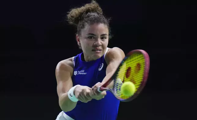 Italy's Jasmine Paolini returns the ball against Poland's Iga Swiatek during the Billie Jean King Cup semi-final tennis match at Martin Carpena Sports Hall in Malaga, southern Spain, on Monday, Nov. 18, 2024. (AP Photo/Manu Fernandez)