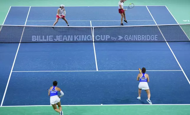 Italy's Sara Errani and Jasmine Paolini, foreground, compete against Poland's Katarzyna Kawa and Iga Swiatek, background, during the Billie Jean King Cup semi-final at Martin Carpena Sports Hall in Malaga, southern Spain, on Monday, Nov. 18, 2024. (AP Photo/Manu Fernandez)