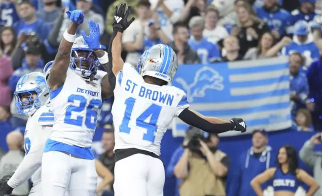 Detroit Lions running back Jahmyr Gibbs (26) celebrates his 1-yard rushing touchdown with wide receiver Amon-Ra St. Brown (14) during the first half of an NFL football game against the Indianapolis Colts, Sunday, Nov. 24, 2024, in Indianapolis. (AP Photo/Michael Conroy)