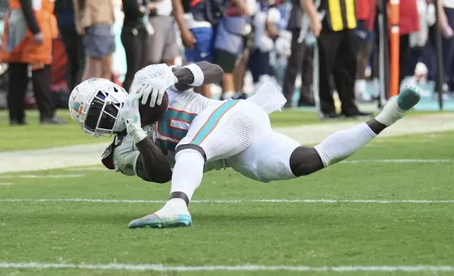 Miami Dolphins wide receiver Tyreek Hill (10) completes a first down during the first half of an NFL football game against the New England Patriots, Sunday, Nov. 24, 2024, in Miami Gardens, Fla. (AP Photo/Lynne Sladky)