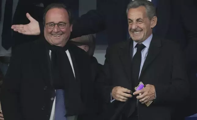 Former French Presidents Nicolas Sarkozy, right, and Francois Hollande smile on the stands before the UEFA Nations League soccer match between France and Israel at the Stade de France stadium in Saint-Denis, outside Paris, Thursday Nov. 14, 2024. (AP Photo/Thibault Camus)