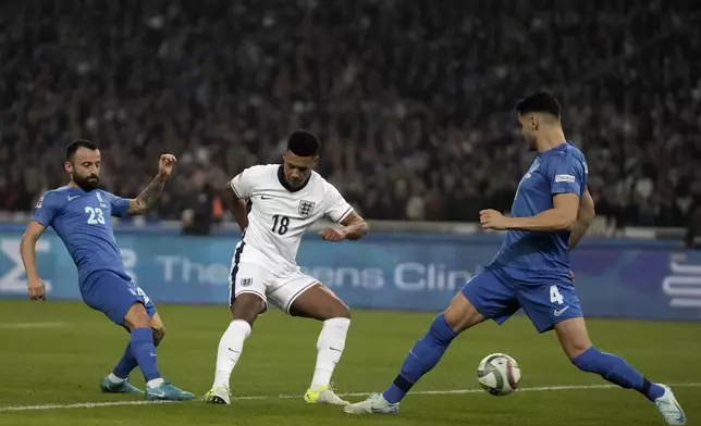 England's Ollie Watkins, center, shoots to score his sidesfirst goal past Ntinos Mavropanos of Greece, right, during the UEFA Nations League Group F soccer match between Greece and England at Olympic Stadium in Athens, Thursday, Nov. 14, 2024. (AP Photo/Thanassis Stavrakis)