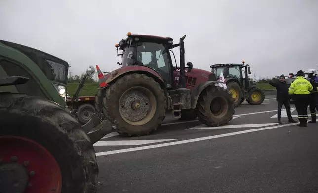 Farmers block a speedway to protest the EU-Mercosur trade agreement, Monday, Nov. 18, 2024 in Velizy-Villacoublay outside Paris. (AP Photo/Christophe Ena)