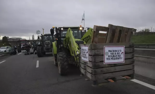 Farmers block a speedway to protest the EU-Mercosur trade agreement, Monday, Nov. 18, 2024 in Velizy-Villacoublay outside Paris. (AP Photo/Christophe Ena)