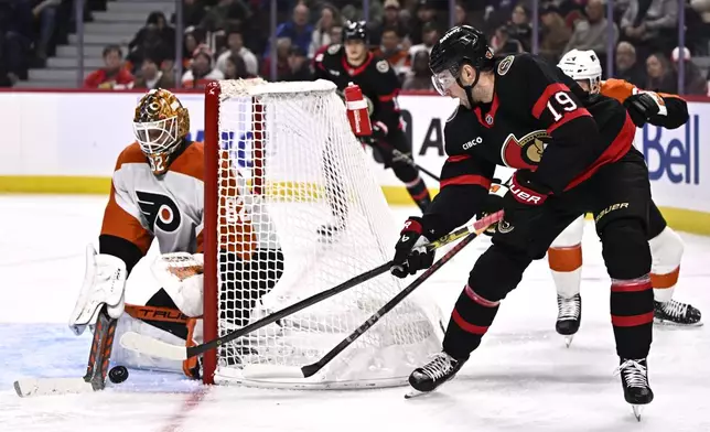 Ottawa Senators right wing Drake Batherson (19) tries wrap the puck around the net of Philadelphia Flyers goaltender Ivan Fedotov, left, during second-period NHL hockey game action in Ottawa, Ontario, Thursday, Nov. 14, 2024. (Justin Tang/The Canadian Press via AP)