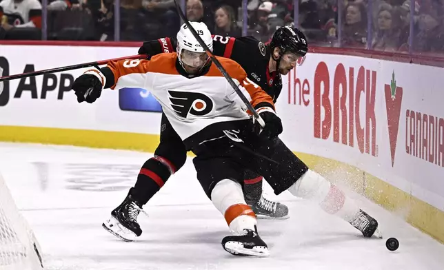 Philadelphia Flyers right wing Garnet Hathaway (19) gets dragged down by Ottawa Senators defenseman Thomas Chabot (72) during the first period of an NHL hockey game, Thursday, Nov. 14, 2024 in Ottawa, Ontario. (Justin Tang/The Canadian Press via AP)