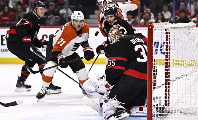 Philadelphia Flyers right wing Tyson Foerster (71) and Ottawa Senators defenseman Artem Zub (2) watch the puck bounce after a save by goaltender Linus Ullmark (35) during the first period of an NHL hockey game, Thursday, Nov. 14, 2024 in Ottawa, Ontario. (Justin Tang/The Canadian Press via AP)