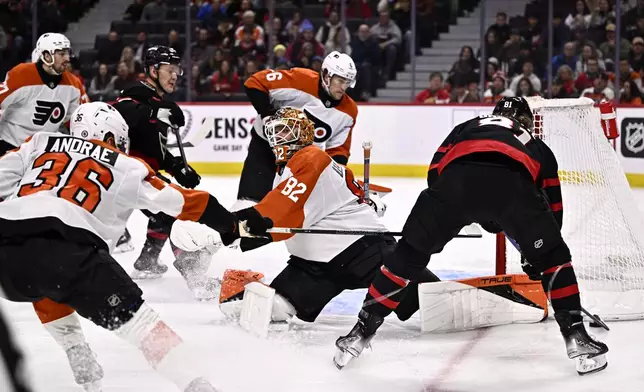 Philadelphia Flyers goaltender Ivan Fedotov (82) stretches out with his pads to make a save as Ottawa Senators right wing Adam Gaudette (81) looks for the rebound behind the net during the second period of an NHL hockey game, Thursday, Nov. 14, 2024 in Ottawa, Ontario. (Justin Tang/The Canadian Press via AP)