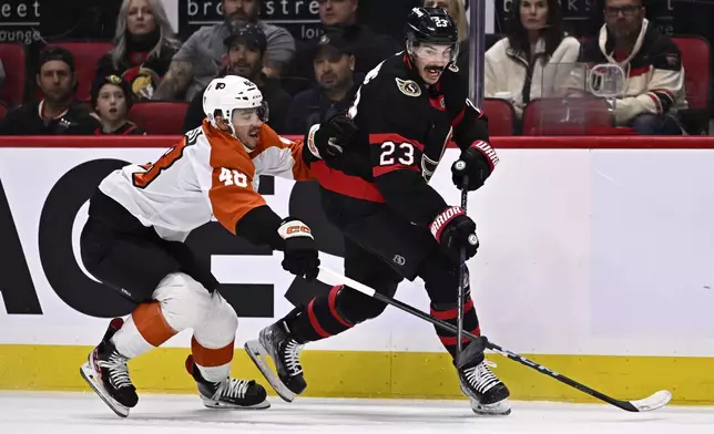 Ottawa Senators defenseman Travis Hamonic (23) tries to keep Philadelphia Flyers center Morgan Frost (48) away from the puck during the first period of an NHL hockey game, Thursday, Nov. 14, 2024 in Ottawa, Ontario. (Justin Tang/The Canadian Press via AP)