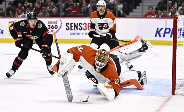 Philadelphia Flyers goaltender Ivan Fedotov (82) dives to cover the puck in front of Ottawa Senators center Josh Norris (9) during second-period NHL hockey game action in Ottawa, Ontario, Thursday, Nov. 14, 2024. (Justin Tang/The Canadian Press via AP)