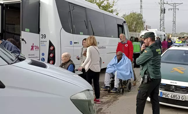 Residents are moved out of the nursing home where least 10 people have died in a fire in Zaragoza, Spain, Friday, Nov. 15, 2024. (AP Photo/Ferran Mallol )