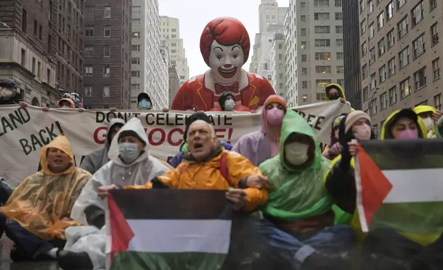 Pro-Palestinian protesters demonstrate on Sixth Avenue during the Macy's Thanksgiving Day Parade, Thursday, Nov. 28, 2024, in New York. (AP Photo/Julia Demaree Nikhinson)