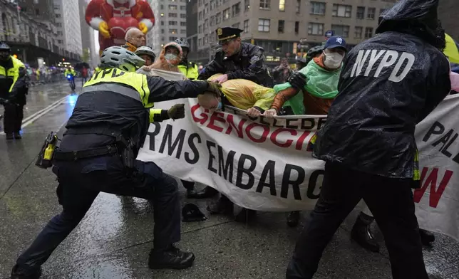 New York Police arrest Pro-Palestinian protesters who were demonstrating on Sixth Avenue during the Macy's Thanksgiving Day Parade, Thursday, Nov. 28, 2024, in New York. (AP Photo/Julia Demaree Nikhinson)