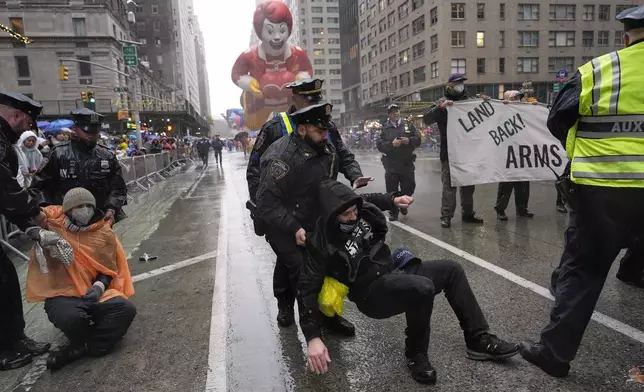 New York Police arrest Pro-Palestinian protesters who were demonstrating on Sixth Avenue during the Macy's Thanksgiving Day Parade, Thursday, Nov. 28, 2024, in New York. (AP Photo/Julia Demaree Nikhinson)