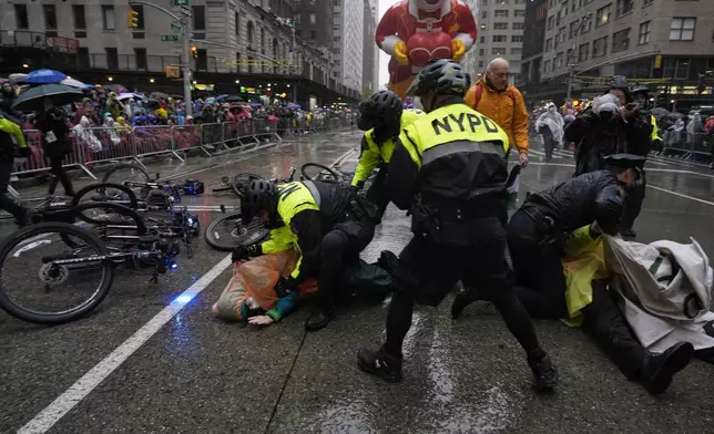 New York Police arrest Pro-Palestinian protesters who were demonstrating on Sixth Avenue during the Macy's Thanksgiving Day Parade, Thursday, Nov. 28, 2024, in New York. (AP Photo/Julia Demaree Nikhinson)