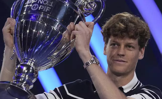 Italy's Jannik Sinner holds the trophy as ATP world best player at the ATP World Tour Finals at the Inalpi Arena, in Turin, Italy, Monday, Nov. 11, 2024. Sinner was presented with the trophy for finishing the year ranked No. 1. (AP Photo/Antonio Calanni)