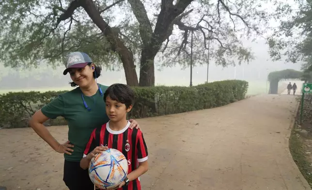 Charu Shankar stands with her son Agastya Shankar Laul in Lodhi Gardens on a smoggy morning in New Delhi, India, Friday, Nov. 15, 2024. (AP Photo/Manish Swarup)