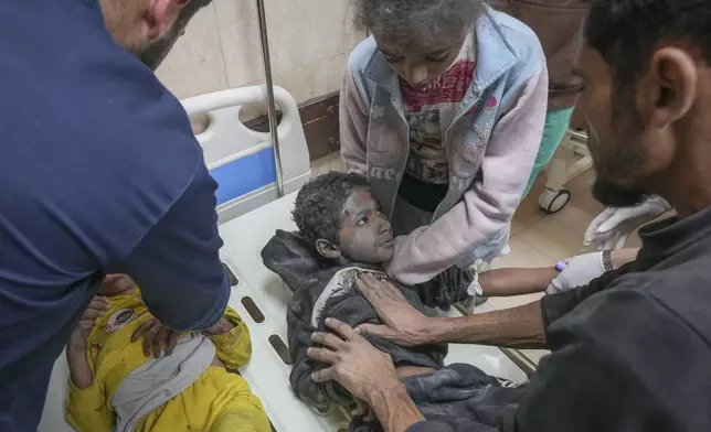 Injured children during an overnight Israeli army strike are assisted upon their arrival at the hospital in Deir al-Balah, Gaza Strip, Sunday Nov. 24, 2024. (AP Photo/Abdel Kareem Hana)