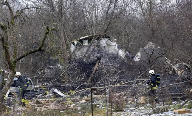 Lithuanian Emergency Ministry employees work at the site where a DHL cargo plane crashed into a house near Vilnius, Lithuania, Monday, Nov. 25, 2024. (AP Photo/Mindaugas Kulbis)