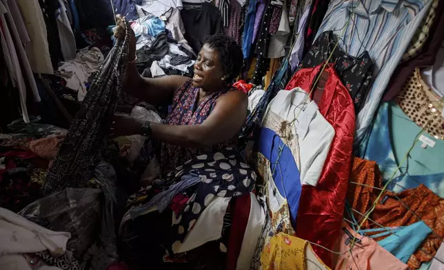 A second-hand retailer sorts out clothes at Kantamanto, one of the world's largest second-hand clothing markets, in Accra, Ghana, Saturday, Oct. 26, 2024. (AP Photo/Misper Apawu)