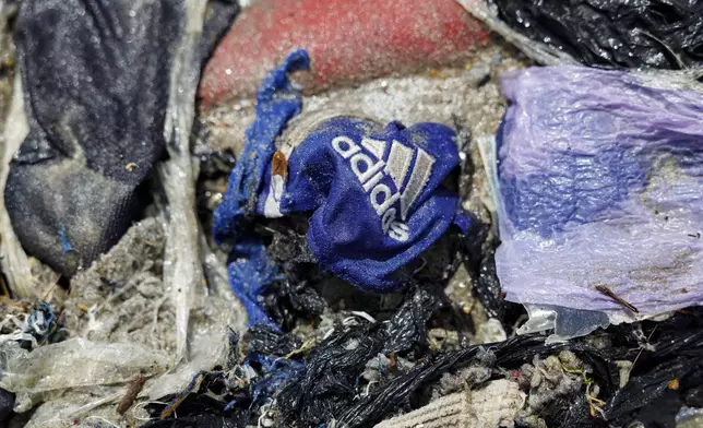 Second-hand clothes and waste pollute the beach shore at Jamestown in Accra, Ghana,Saturday, Oct. 19, 2024. (AP Photo/Misper Apawu)