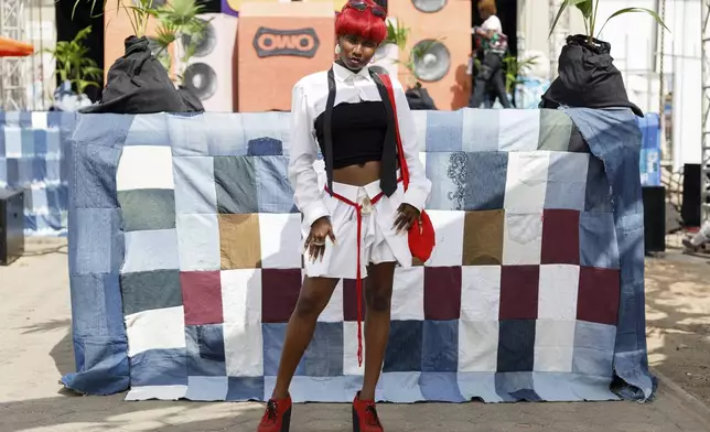 A lady poses for a photograph during a thrift and an upcycle show in Accra, Ghana, Sunday, Oct. 27, 2024. (AP Photo/Misper Apawu)