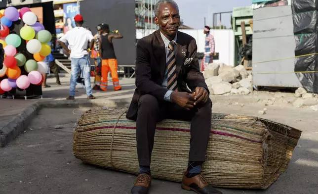 A man dressed in second-hand clothes attends a thrift and an upcycle show in Accra, Ghana, Sunday, Oct. 27, 2024. (AP Photo/Misper Apawu)