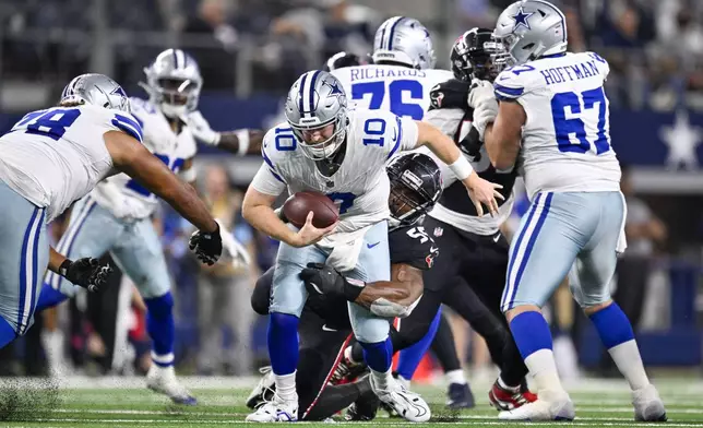 Dallas Cowboys quarterback Cooper Rush (10) is sacked by Houston Texans defensive end Danielle Hunter during the second half of an NFL football game, Monday, Nov. 18, 2024, in Arlington, Texas. (AP Photo/Jerome Miron)