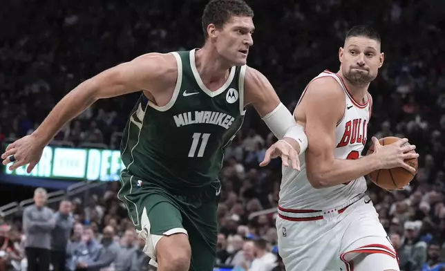 Chicago Bulls' Nikola Vucevic tries to get past Milwaukee Bucks' Brook Lopez during the first half of an NBA basketball game Wednesday, Nov. 20, 2024, in Milwaukee. (AP Photo/Morry Gash)