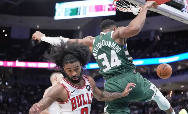 Milwaukee Bucks' Giannis Antetokounmpo dunks over Chicago Bulls' Coby White during the second half of an NBA basketball game Wednesday, Nov. 20, 2024, in Milwaukee. Tyhe Bucks won 122-106. (AP Photo/Morry Gash)