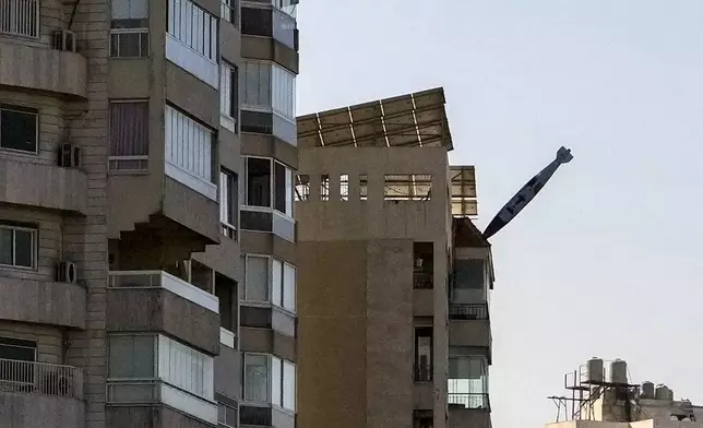 A bomb dropped from an Israeli jet prepares to hit a building in Tayouneh, Beirut, Lebanon, Friday, Nov. 15, 2024. (AP Photo/Hassan Ammar)