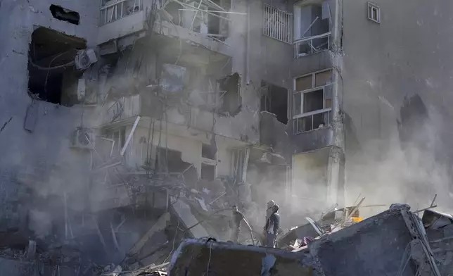 Residents check the site of an Israeli airstrike in Tayouneh, Beirut, Lebanon, Friday, Nov. 15, 2024. (AP Photo/Hassan Ammar)