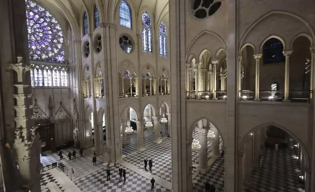 People stroll in Notre-Dame de Paris cathedral while French President Emmanuel Macron visits the restored interiors the monument, Friday, Nov.29, 2024 in Paris. (Christophe Petit Tesson, Pool via AP)