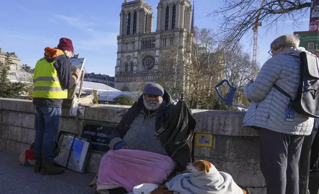 People gather as French President Emmanuel Macron visits the renovated Notre Dame Cathedral Friday, Nov. 29, 2024 in Paris. (AP Photo/Michel Euler)