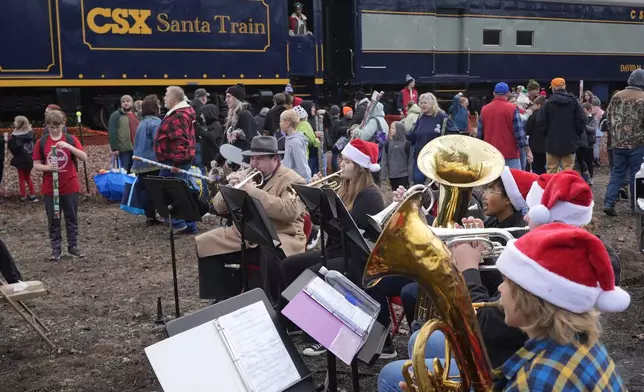 Members of the Twin Springs high school band perform during the 82nd run of the CSX Santa Train, Saturday, Nov. 23, 2024, in Dungannon, Va. (AP Photo/George Walker IV)