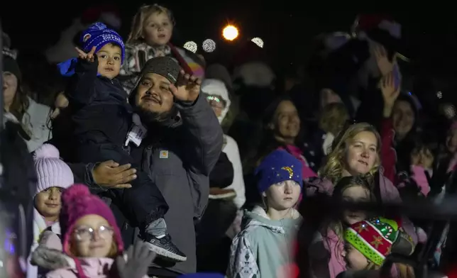 People wave to Santa Claus during a visit of theCSX Holiday Express, Thursday, Nov. 21, 2024, in Erwin, Tenn. (AP Photo/George Walker IV)