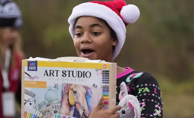 Khylin Barber reacts to a gift she received during the 82nd run of the CSX Santa Train, Saturday, Nov. 23, 2024, in Dungannon, Va. (AP Photo/George Walker IV)