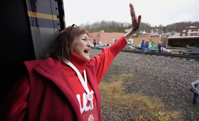 Angie Hensley waves to people during the 82nd run of the CSX Santa Train, Saturday, Nov. 23, 2024, in St. Paul, Va. (AP Photo/George Walker IV)