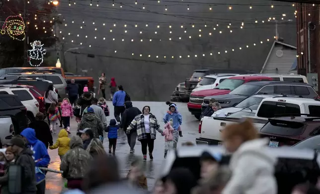 People make their way to the CSX Santa Train, Saturday, Nov. 23, 2024, in Elkhorn City, Ky. (AP Photo/George Walker IV)