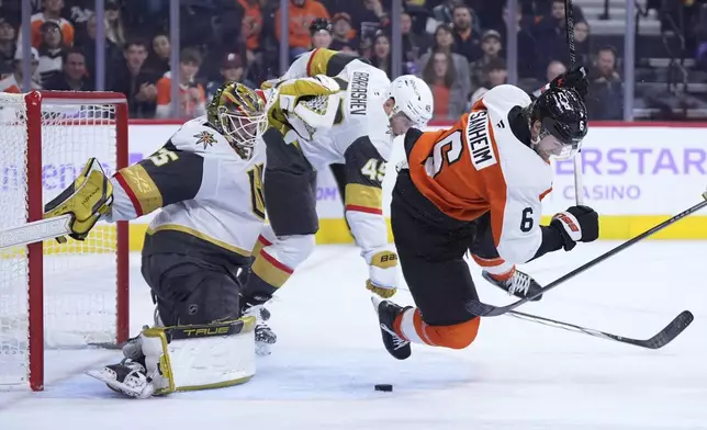 Philadelphia Flyers' Travis Sanheim (6) collides with Vegas Golden Knights' Ivan Barbashev (49) and Ilya Samsonov (35) during overtime in an NHL hockey game, Monday, Nov. 25, 2024, in Philadelphia. (AP Photo/Matt Slocum)