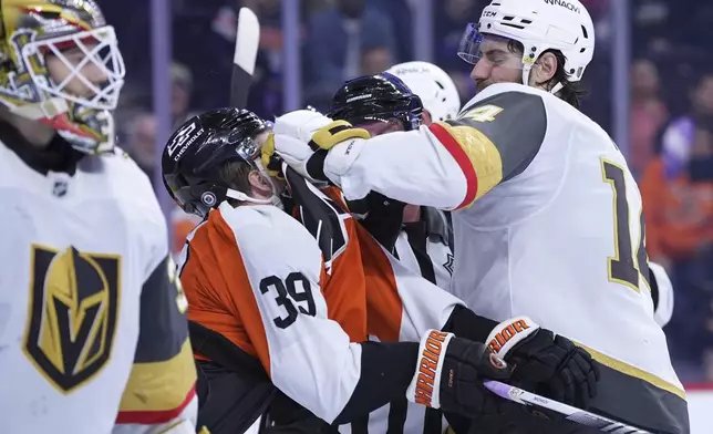 Vegas Golden Knights' Nicolas Hague, right, battles with Philadelphia Flyers' Matvei Michkov during overtime in an NHL hockey game, Monday, Nov. 25, 2024, in Philadelphia. (AP Photo/Matt Slocum)