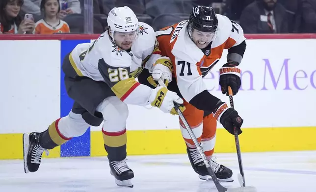 Philadelphia Flyers' Tyson Foerster, right, and Vegas Golden Knights' Alexander Holtz battle for the puck during the third period of an NHL hockey game, Monday, Nov. 25, 2024, in Philadelphia. (AP Photo/Matt Slocum)