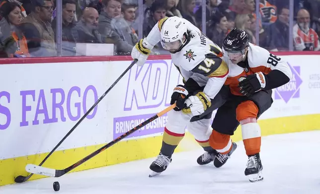 Vegas Golden Knights' Nicolas Hague, left, and Philadelphia Flyers' Joel Farabee battle for the puck during the second period of an NHL hockey game, Monday, Nov. 25, 2024, in Philadelphia. (AP Photo/Matt Slocum)