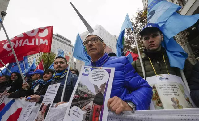 Demonstrators march during a public and private sectors' national strike called by the labor unions to protest against the government's budget law ,in Milan, Italy, Friday, Nov. 29, 2024. (AP Photo/Luca Bruno)