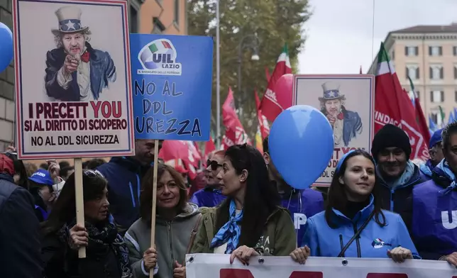 Demonstrators hold placards mocking Italian Infrastructure Minister Matteo Salvini reading " Yes to the right of strike, no to the government's security bill" as they gather during a public and private sectors' national strike called by the labor unions to protest against government's budget law in Rome, Friday, Nov. 29, 2024. (AP Photo/Gregorio Borgia)