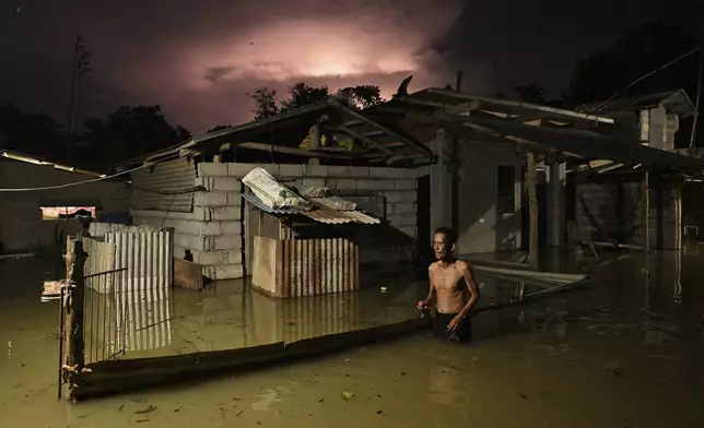 A resident wades through a flooded street caused by heavy rains from typhoon Toraji in Ilagan City, Isabela province, northern Philippines, Tuesday, Nov. 12, 2024. (AP Photo/Noel Celis)