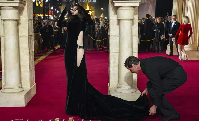 Pedro Pascal, right, adjusts the dress of Lux Pascal as they pose for photographers upon arrival at the premiere of the film 'Gladiator II' on Wednesday, Nov. 13, 2024, in London. (Photo by Scott A Garfitt/Invision/AP)